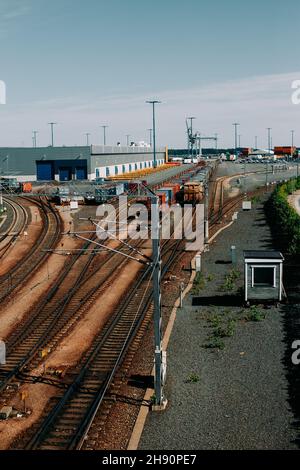 Vue de dessus en perspective sur les trains de marchandises sur plusieurs lignes de voie ferrée et les commutateurs de cour dans une cour de chemin de fer Banque D'Images
