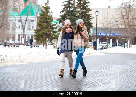 Portrait complet de deux jeunes filles marchant dans un parc d'hiver Banque D'Images