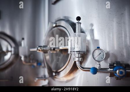 Équipement pour la production de bière artisanale, récipients de fermentation dans la chambre climatique, manomètre à tubes et réservoirs en acier inoxydable. Banque D'Images