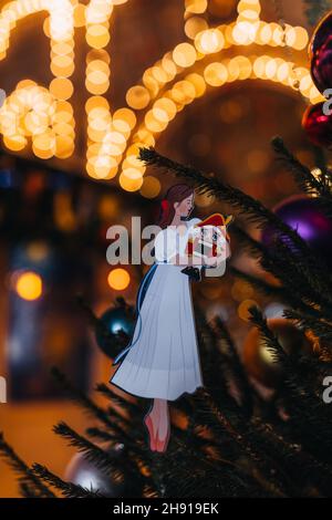 Figurine jouet de Noël d'une fille tenant un casse-noisette.Feux dorés bokeh.Carte postale de Noël festive Banque D'Images