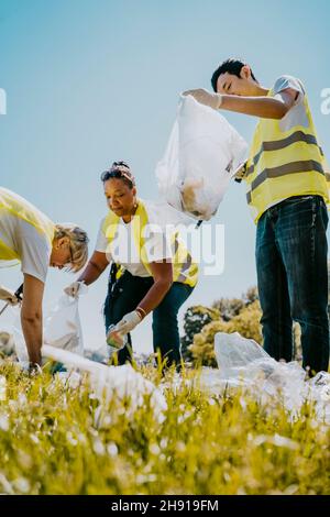 Les écologistes hommes et femmes nettoient les plastiques le jour du soleil Banque D'Images