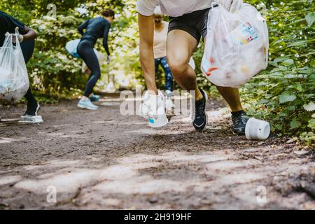 Les écologistes hommes et femmes ramassant les plastiques tout en se blochant dans le parc Banque D'Images