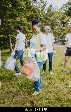 Les écologistes hommes et femmes ramassant les déchets plastiques au parc Banque D'Images