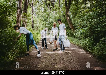 Les écologistes hommes et femmes ramassant les ordures dans le parc Banque D'Images