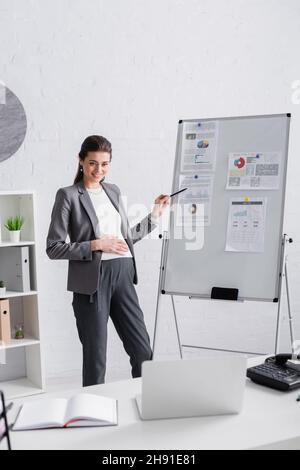 bonne femme enceinte pointant sur le tableau de conférence en ligne Banque D'Images