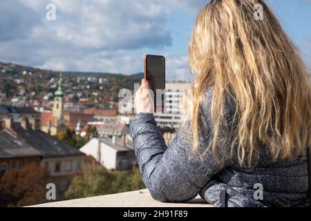 Budapest, Hongrie - 1 novembre 2021: Une femme touristique faisant des photos de voyage de point de repère sur le téléphone , Editorial illustratif. Banque D'Images