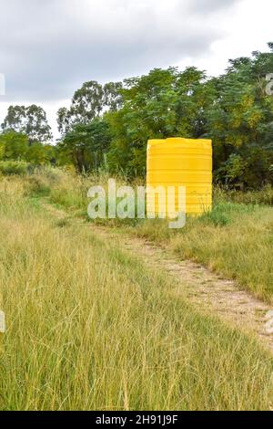 Un grand conteneur jaune de taille industrielle contenant des milliers de litres d'eau dans une ferme près d'un champ en Afrique du Sud utilisé pour stocker l'eau Banque D'Images