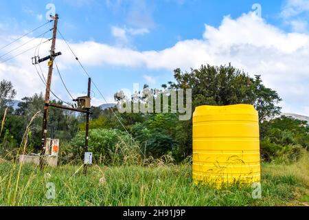 Un grand conteneur jaune de taille industrielle contenant des milliers de litres d'eau dans une ferme près d'un champ en Afrique du Sud utilisé pour stocker l'eau Banque D'Images