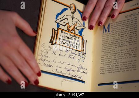 Un assistant de galerie avec le Savoy cocktail Book, Harry Craddock (1876 - 1963), estimé entre £1,500 - £2000, lors d'un appel photo pour les temps forts de la prochaine Classic week Sales, à Christies, Londres.La vente comprend des œuvres d'El Greco et de Constable, ainsi que le microscope de la famille Darwin.Date de la photo: Vendredi 3 décembre 2021. Banque D'Images