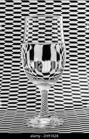 Image artistique de papier à motifs noir et blanc se réfractant à travers un verre et créant des motifs et des formes intéressants. Banque D'Images