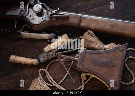 ancienne mousquet de flintlock du xviie siècle avec ballon de poudre et balles led sur terrasse en bois. Banque D'Images