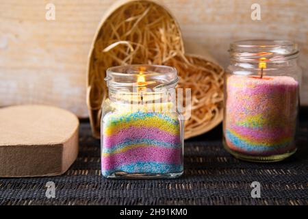 Les enfants ont fait des bougies en poudre de cire colorées dans la maison en versant de la poudre dans le vieux pot de nourriture pour bébé et en insérant la mèche à l'intérieur.Concept de passe-temps. Banque D'Images