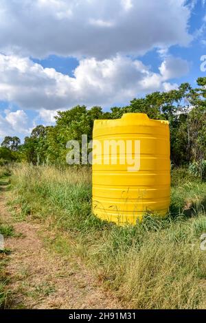 Un grand conteneur jaune de taille industrielle contenant des milliers de litres d'eau dans une ferme près d'un champ en Afrique du Sud utilisé pour stocker l'eau Banque D'Images