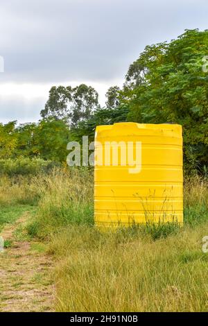 Un grand conteneur jaune de taille industrielle contenant des milliers de litres d'eau dans une ferme près d'un champ en Afrique du Sud utilisé pour stocker l'eau Banque D'Images