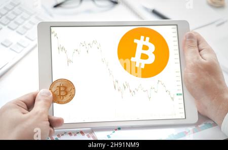 Logo de Bitcoin dans la tablette.Jeton BTC crypto-monnaie. Tableau des prix des actions.Trading blockchain plate-forme pour acheter, vendre sur échange décentralisé DEX.Di Banque D'Images