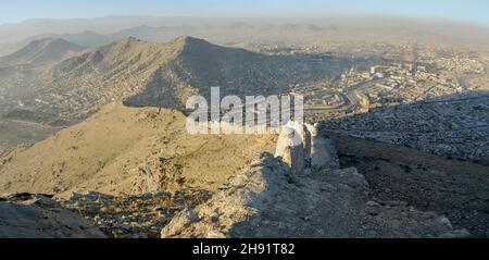 Vue aérienne des établissements informels et du centre-ville depuis la colline de Kaboul en Afghanistan avec des tours de transmission au sommet de la montagne dans un Banque D'Images