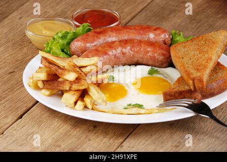 Oeufs au plat avec des saucisses, du pain grillé et trempettes Banque D'Images