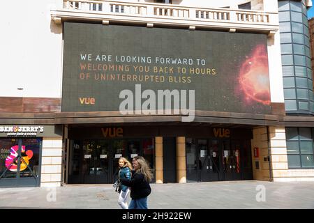 Des piétons marchent devant un message affiché à l'avant d'un cinéma vue dans le centre de Londres, avant la prochaine étape de l'assouplissement du verrouillage. Banque D'Images