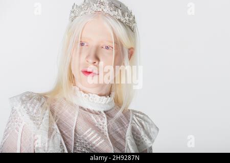 Modèle Albino en blouse et couronne à l'écart isolée sur blanc Banque D'Images