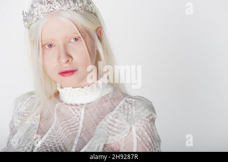 Portrait de la jeune femme albino dans la couronne et le chemisier regardant la caméra isolée sur blanc Banque D'Images