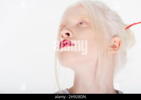 Portrait de femme albino avec des lèvres rouges regardant loin isolé sur blanc Banque D'Images