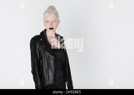 Femme albino tendance en cuir veste avec des lèvres noires posant isolé sur blanc Banque D'Images