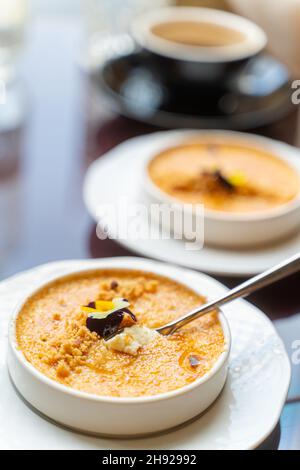 Cuillère en crème brûlée, servi avec du café dans le café.Lumière naturelle, mise au point verticale sélective Banque D'Images