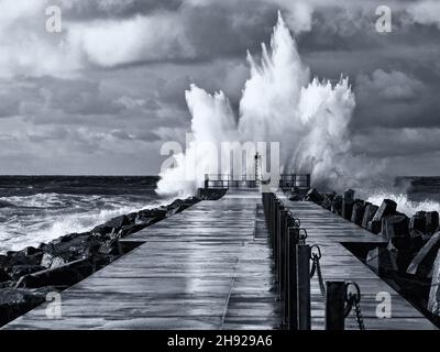 Photo en noir et blanc du phare sur la jetée de Norre Vorupor pendant la tempête et les hautes vagues, Jutland, Danemark Banque D'Images