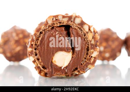 Deux bonbons au chocolat entiers et demi avec noix, gros plan, isolés sur du blanc. Banque D'Images