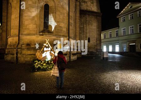 Gmund, Allemagne.03ème décembre 2021.03 décembre 2021, Bade-Wurtemberg, Schwäbisch Gmünd : une personne se tient devant une scène de la nativité illuminée sur la place du marché vide de Schwäbisch Gmünd.Depuis vendredi 03.12.2021, les commerçants de Noël de Schwäbisch Gmünd ont été autorisés à vendre leurs marchandises dans des bâtiments commerciaux vides.La campagne se déroule jusqu'à la veille de Noël.Photo: Tom Weller/dpa crédit: dpa Picture Alliance/Alay Live News Banque D'Images