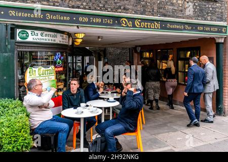 Personnes assises devant le Da Corradi Sandwich Bar à l'entrée du marché Shepherd, Londres, Royaume-Uni. Banque D'Images