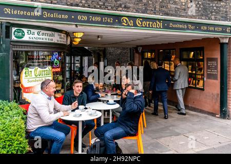 Personnes assises devant le Da Corradi Sandwich Bar à l'entrée du marché Shepherd, Londres, Royaume-Uni. Banque D'Images