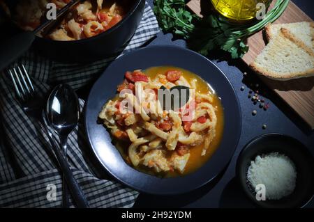 Cuisine italienne.Plat de tripe de bœuf typique avec sauce tomate et croûtons de pain dans l'assiette sur la table.Directement au-dessus. Banque D'Images