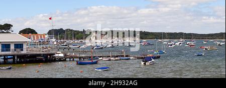 Port de Poole, Dorset, Angleterre - juin 2021 : petits bateaux amarrés dans le port de Poole près du bâtiment du club de voile et de la jetée Banque D'Images