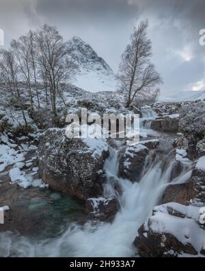 La rivière Frozen Coupall passe le long de Stob Dearg (le sommet le plus important de Buachille Etive More) lors d'une journée hivernale à Glencoe, en Écosse, au Royaume-Uni. Banque D'Images