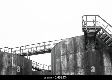 Alimenter l'ancien réservoir de produit chimique en huile de baril dans une usine industrielle abandonnée. Banque D'Images