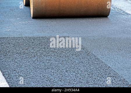 Le rouleau à vapeur compact aplatit l'asphalte.Le rouleau vibrant lourd sur les travaux de revêtement d'asphalte.Fragment de roue de rouleau, route urbaine est en construction Banque D'Images