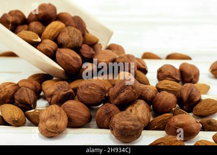Gros plan noisettes et amandes sur un fond en bois.Noix dans une pelle en bois Banque D'Images