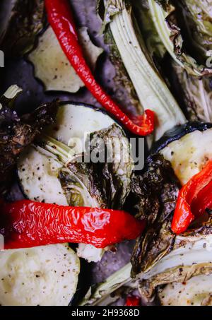 Mélange de légumes cuits au four.Paprika rouge, courgettes et feuilles de chou-fleur avec huile d'olive et .Plats végétariens. Banque D'Images