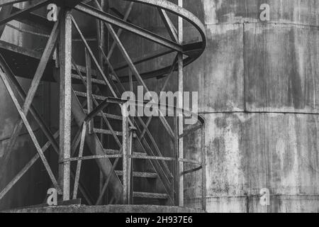 Alimenter l'ancien réservoir de produit chimique en huile de baril dans une usine industrielle abandonnée.Échelle à une citerne sale. Banque D'Images