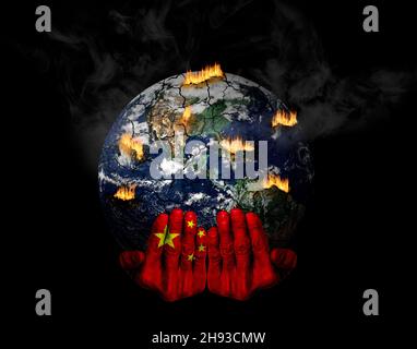 Les mains peintes avec le drapeau chinois tenant une planète stressée en crise.Concept du rôle de la Chine dans les crises climatiques; catastrophes naturelles, réchauffement climatique, Banque D'Images