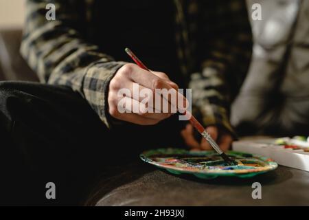 Gros plan sur les mains d'artiste peintre inconnu féminin avec palette de couleurs et pinceaux prêts à faire de l'art de loisirs professionnel ou ama Banque D'Images