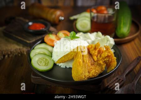 Ayam geprek est un poulet frit croustillant indonésien écrasé et mélangé avec des sambal chauds et épicés. Banque D'Images
