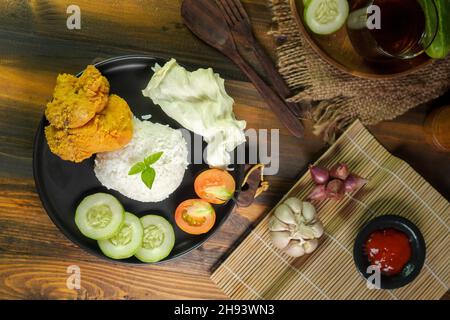 Ayam geprek est un poulet frit croustillant indonésien écrasé et mélangé avec des sambal chauds et épicés. Banque D'Images