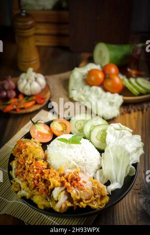 Ayam geprek est un poulet frit croustillant indonésien écrasé et mélangé avec des sambal chauds et épicés Banque D'Images