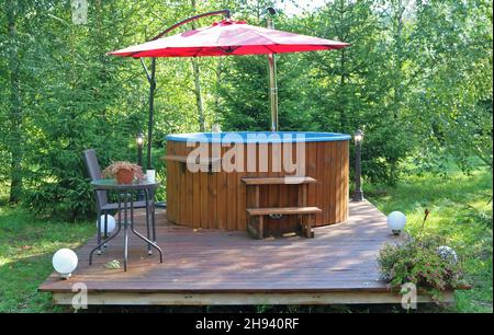 Bain de style japonais - tonneau en bois avec eau chaude.Installé dans la forêt Banque D'Images