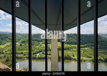 Pont de la vallée de la Moselle par en dessous, accent sur le pilier gris.Photographié à travers une grille.Rivière et de nombreux arbres verts.Allemagne. Banque D'Images