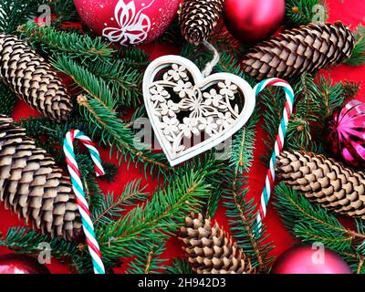 Décoration de Noël en forme de coeur avec branches de sapin, bonbons et cônes Banque D'Images