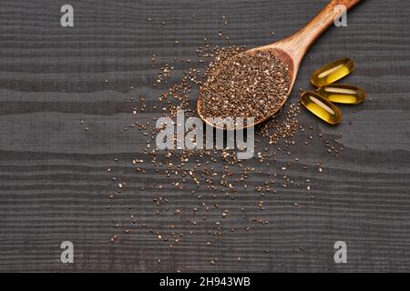 Graines de chia naturel bio et pelle en bois gros plan sur fond en bois ou table Banque D'Images