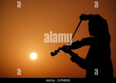 musicien jouant du violon.Musique et sonorité musicale. Images silhouettes de l'homme musicien Banque D'Images